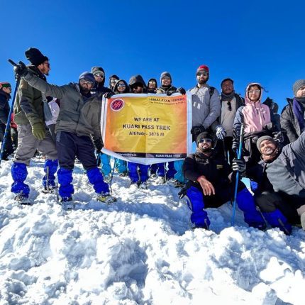 Kuari Pass Summit Victory – Celebrating success at the Kuari Pass summit with stunning panoramic views of the snow-capped Himalayan peaks.